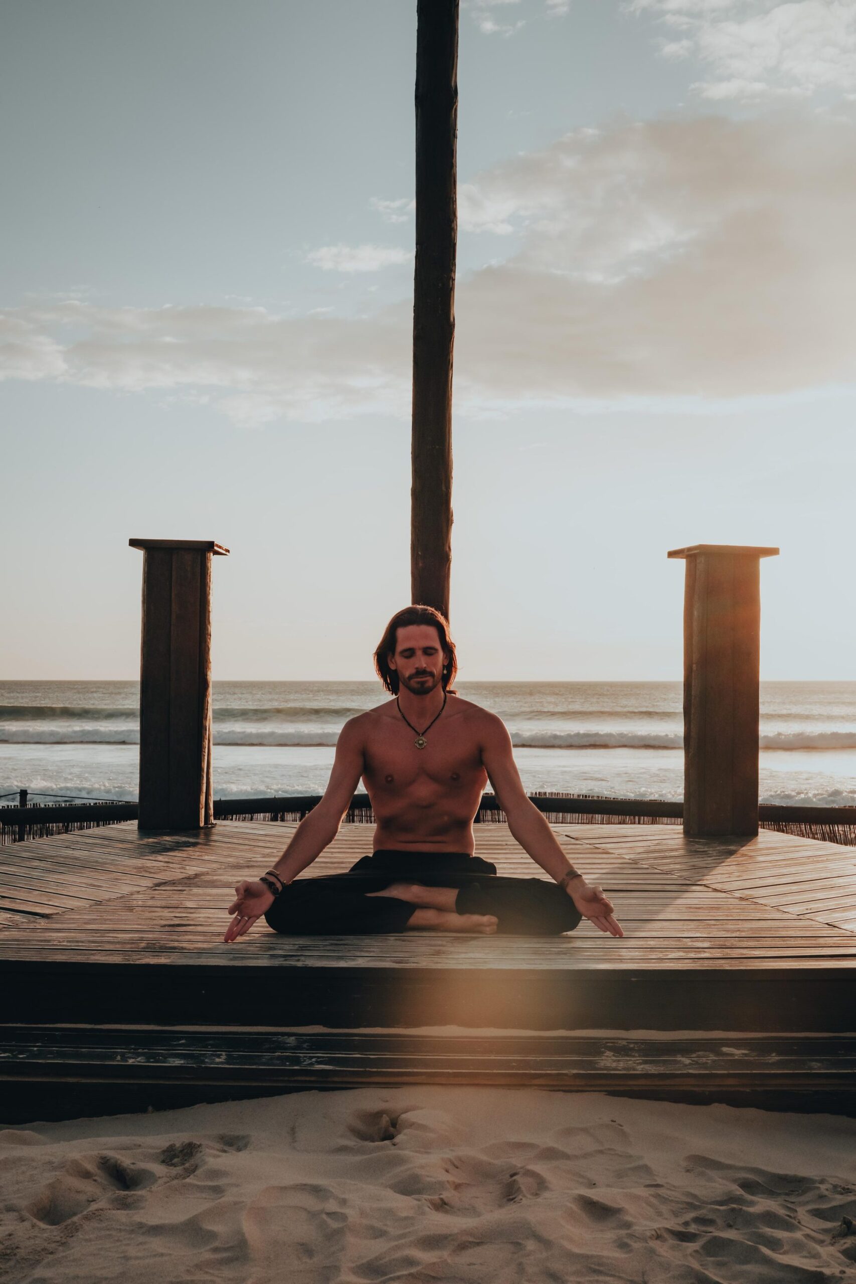 Breath practice on a wooden deck facing the Atlantic at sunset