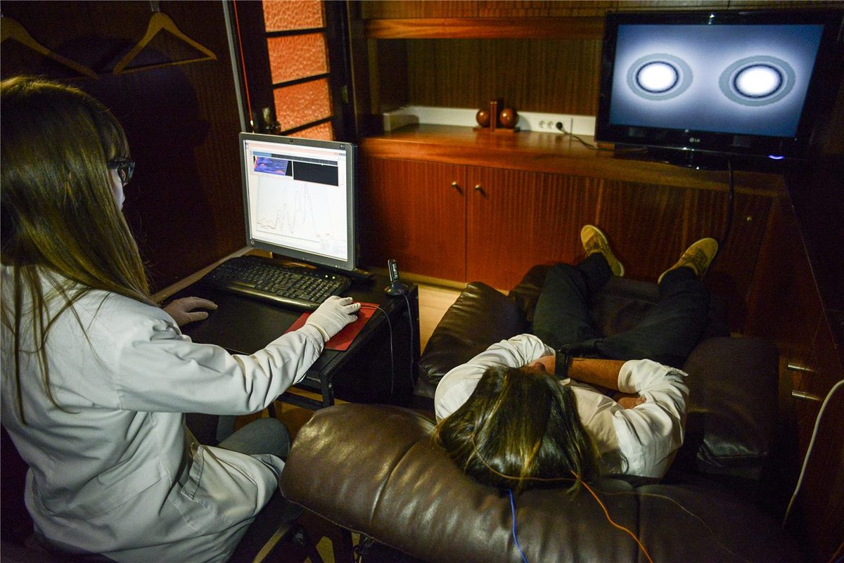 A neurofeedback session in progress, client at a screen with electrodes placed