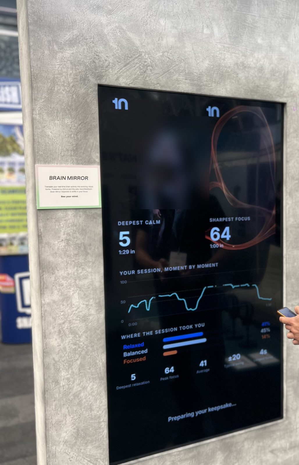 The Brain Mirror display showing a visitor's live EEG readings on a tall screen