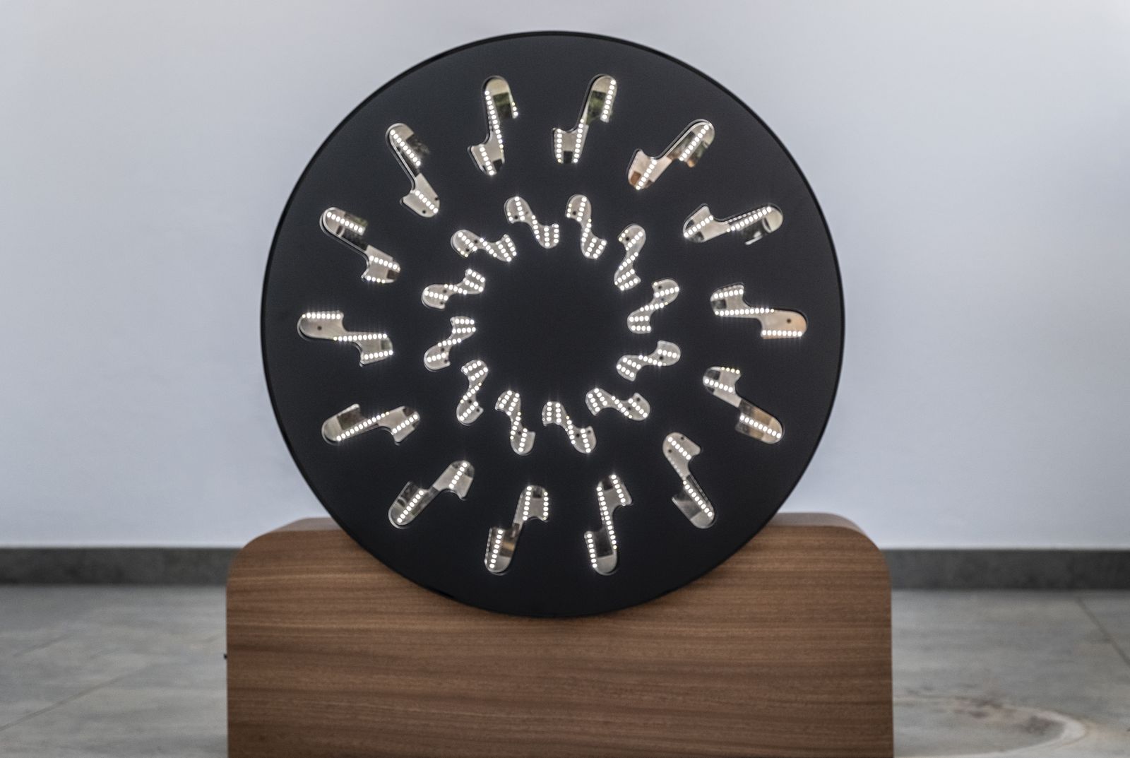 A round flicker-light device mounted on a wooden stand