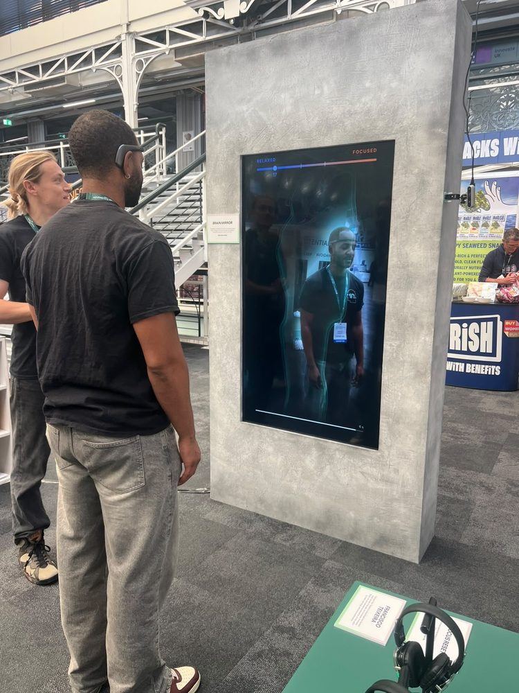 A guest standing at the Brain Mirror screen, reading their live results