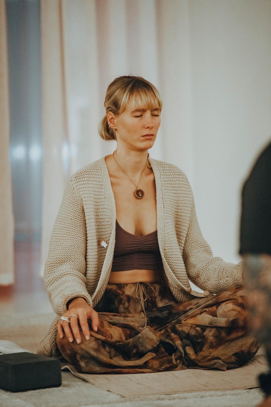 A participant meditating cross-legged in soft daylight